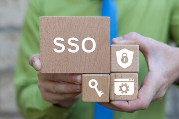 Business man holding wooden blocks sees abbreviation: SSO. Single Sign On ( SSO ) concept. Single Sign-On is an authentication process with a single set of login credentials.