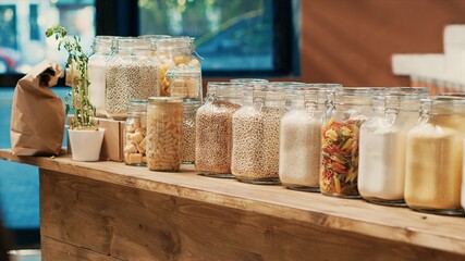 Bulk products in reusable jars on display at local supermarket to protect environmental changes. Eco friendly zero waste eco store with homegrown additives free pasta, spices and sauces.