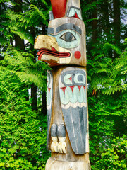 Traditional native american totem pole standing in forest