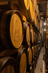 Worker in wine , whiskey or brandy warehouse sorting and rotating barrel . Two winemakers in vintage , traditional wine factory rolls barrel . Shot on ARRI ALEXA Cinema Camera in Slow Motion .