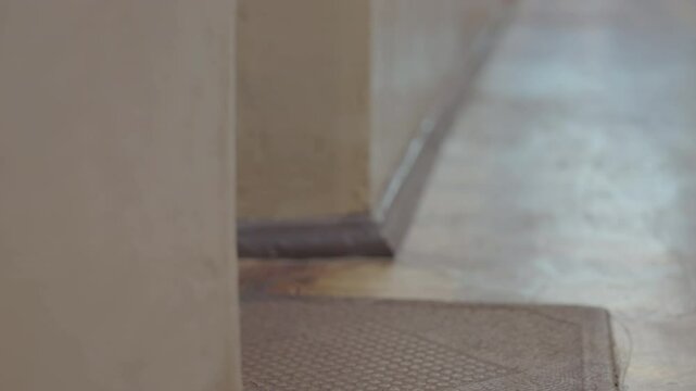 Man Collecting Stacked Packages from Doormat | Low-Angle View of Hands Picking Up Cardboard Boxes Stack | Home Delivery Scene in Urban Apartment Hallway | Static Shot of E-commerce Order Pickup