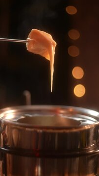 Fondue Fork Lifting Bread with Melted Fondue Cheese Vertical Video