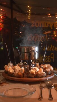 Hot Fondue Pot on Table with Bread Pieces During Romantic Dinner Vertical Video