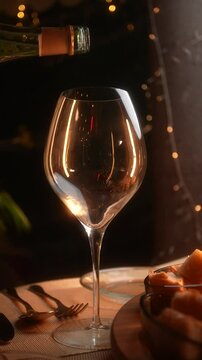 Champagne Pouring into Glass During Romantic Dinner with Twinkling Lights Vertical Video
