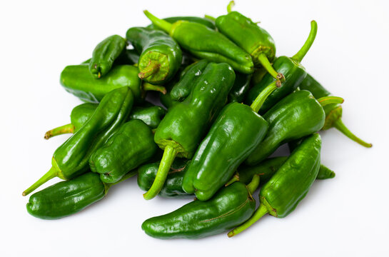 Closeup of pile of fresh organic green padron peppers on white background. Healthy nutrition concept..