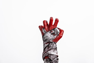 A terrifying red demon hand wrapped in a shroud, reaching out menacingly on a white studio background. This eerie, Halloween-themed image evokes fear and horror with its ghostly, undead appearance.