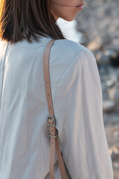 Woman in beige suit with bag strap detail