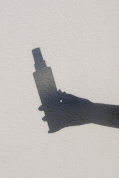 The outline of a hand holding a skincare product vending device