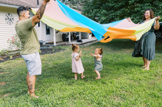 playful happy lgbtq family with mothers and toddler daughters
