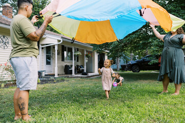 playful happy lgbtq family with mothers and toddler daughters