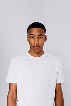 Serious man with neutral expression wearing white t shirt