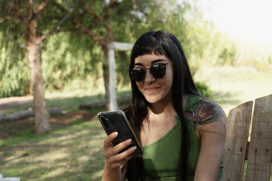 Smiling latin woman using smartphone