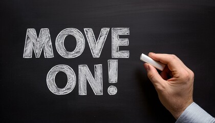 Close up of a man hand writing the move on! with white chalk on a blackboard 