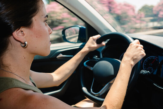 A serious woman driving a vehicle during a road trip through Spain