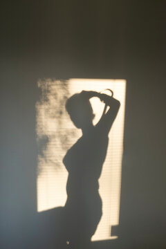 Golden hour light reflection on wall & human figure shadow silhouette