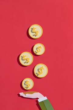 Hand Catching Dollar Coins On Red Background