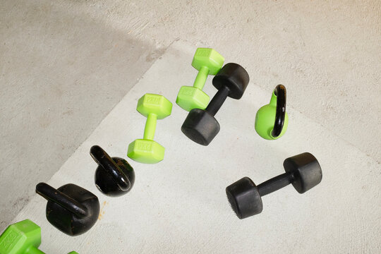 Sport equipment dumbbells and kettlebells and hard direct flashlight - Powered by Adobe