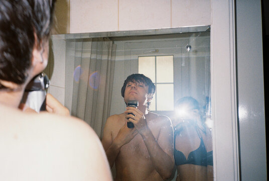 A man and woman in a bathroom taking selfie