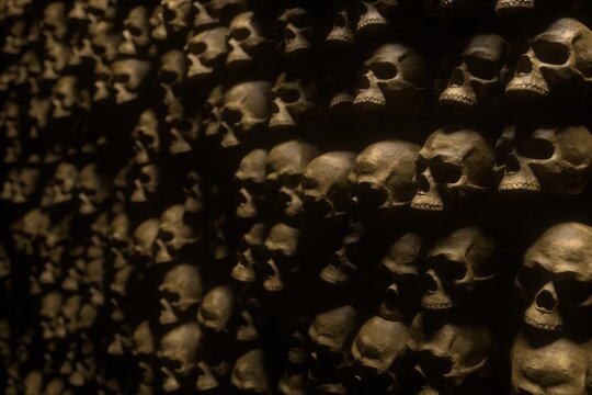3d render of ancient human skulls and bones stacked in catacombs