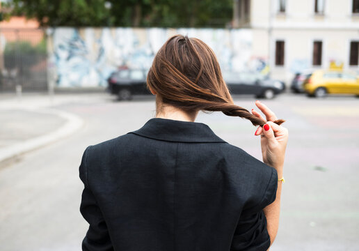 Woman in Black Coat Twirling Hair
