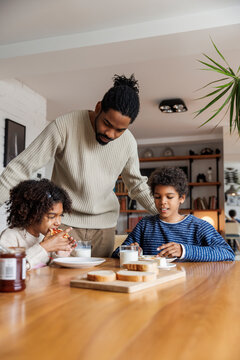 Father with children having breakfast at home