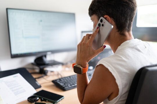 Businesswoman using smartphone and working at home