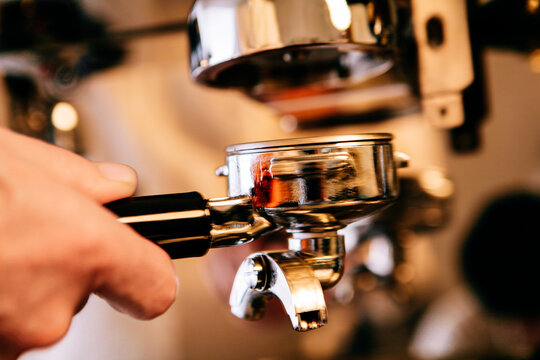 Close Up of a Barista's Hand Holding a Portafilter
