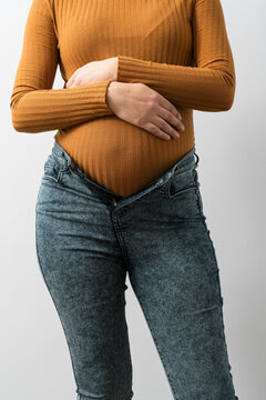 Unrecognizable pregnant woman arms crossed over her belly