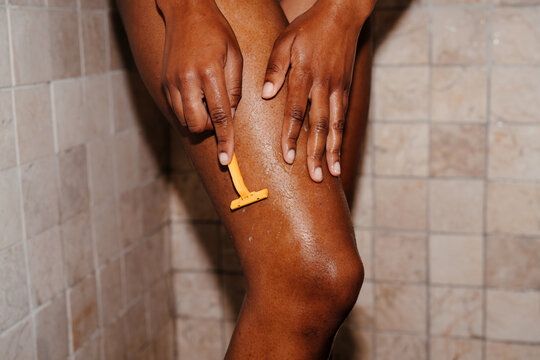 Black woman shaving her leg
