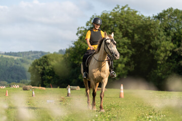 Young woman practicing horseback riding in an equestrian center