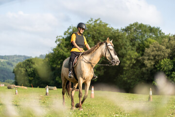 Young horse rider training for equestrian competition in open field