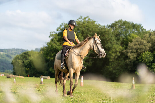 Young horse rider training for equestrian competition in open field