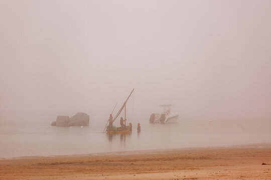 Fishing dhows on a misty morning as the sun rises 
