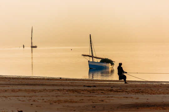 Anonymous fisherman pulling in his net at dawn in Mozambique