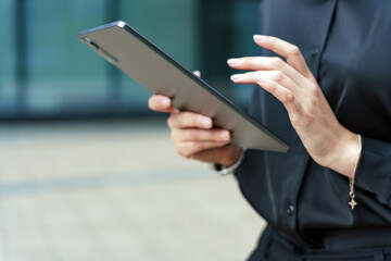 Close-up of hands interacting with a tablet, showcasing focus and precision in a professional setting.