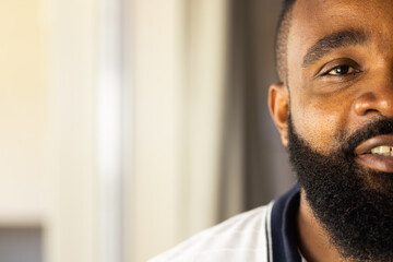Obraz premium Smiling African American man with beard looking at camera, close-up portrait indoors, copy space