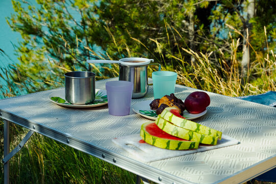 Picnic Table Setting With Watermelon and Cups Outdoors