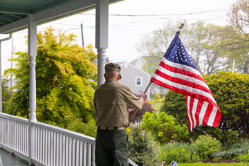 Senior military man Veteran display American Flag at Home 