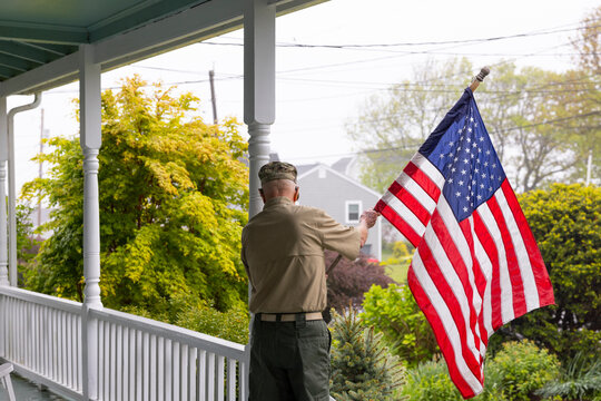 Senior military man Veteran display American Flag on porch