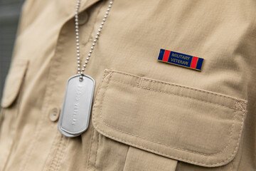 Military soldier dog tag on uniform veteran with badge