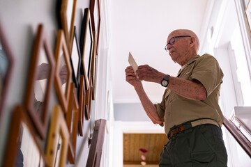Active Senior Citizen military looking at old photographs at home