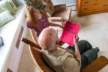 At home Young Girl give card portrait thanking veteran tribute 