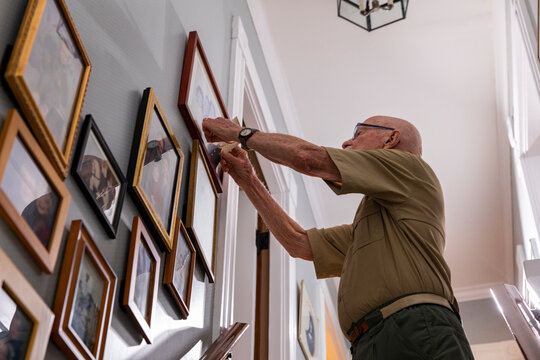 Senior Veteran Portrait smile  at home looking at vintage photograph 