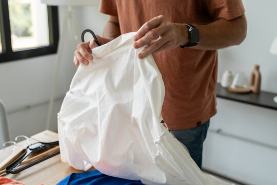 Anonymous Man Folding Clothes

