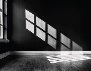 Obraz premium A captivating interplay of light and shadow radiates through a dark room, illuminating the wooden floor. monocrome concept