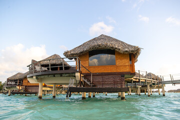 Overwater bungalow hut on a tropical island resort. The popular tourist accommodations are luxurious with a view of paradise. 
