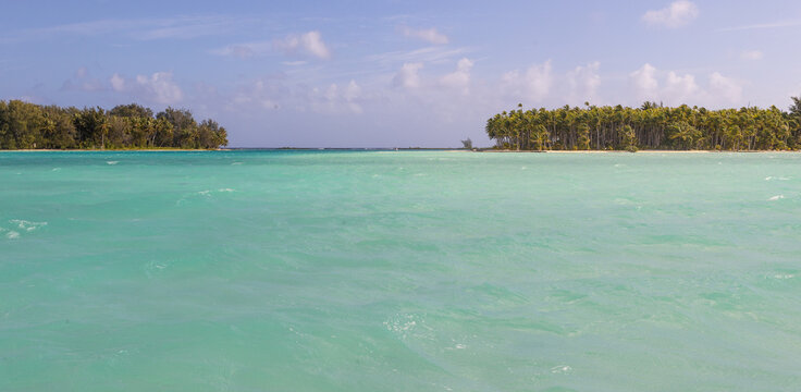 Tropical island Bora Bora surrounded by beautiful motus and azure blue sea water in the South Pacific ocean.