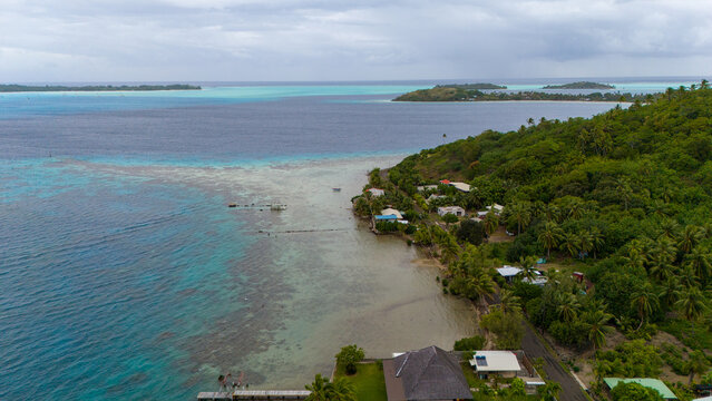 Tropical island Bora Bora surrounded by beautiful motus and azure blue sea water in the South Pacific ocean.