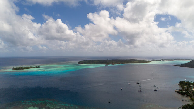 Tropical island Bora Bora surrounded by beautiful motus and azure blue sea water in the South Pacific ocean.