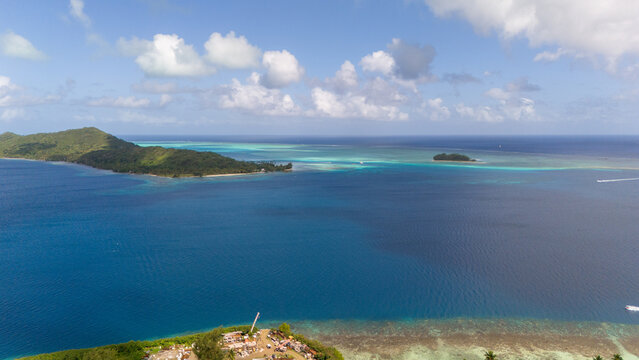 Tropical island Bora Bora surrounded by beautiful motus and azure blue sea water in the South Pacific ocean.